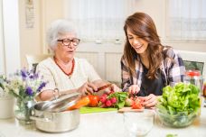 Chopping veggies young+older woman